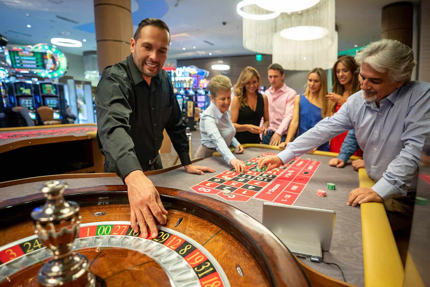 赌场工人准备在轮盘上放球,而其他人仍在表上打注笑